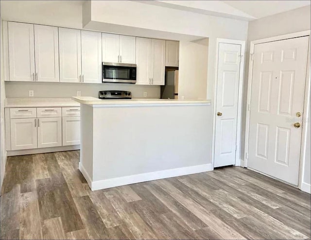 kitchen featuring light countertops, appliances with stainless steel finishes, white cabinets, and wood finished floors