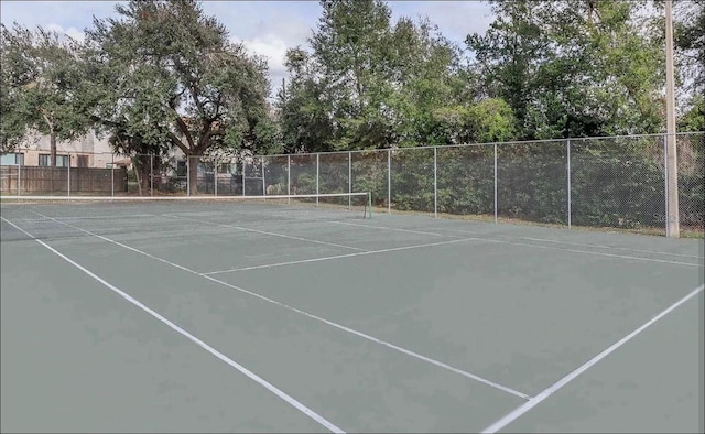 view of tennis court featuring fence