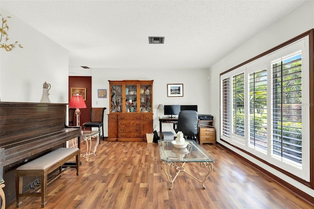 living area featuring visible vents and wood finished floors