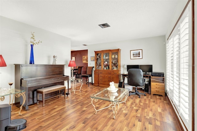 home office featuring light wood-style flooring and visible vents