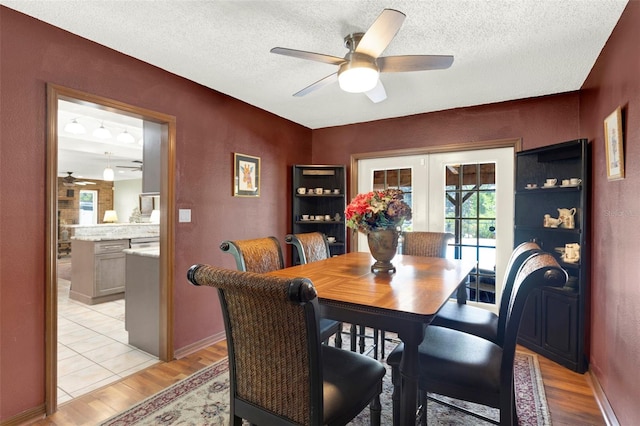 dining area featuring light wood-type flooring, a ceiling fan, and a healthy amount of sunlight