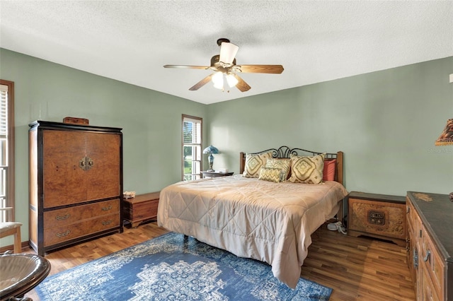 bedroom featuring a ceiling fan, a textured ceiling, and wood finished floors