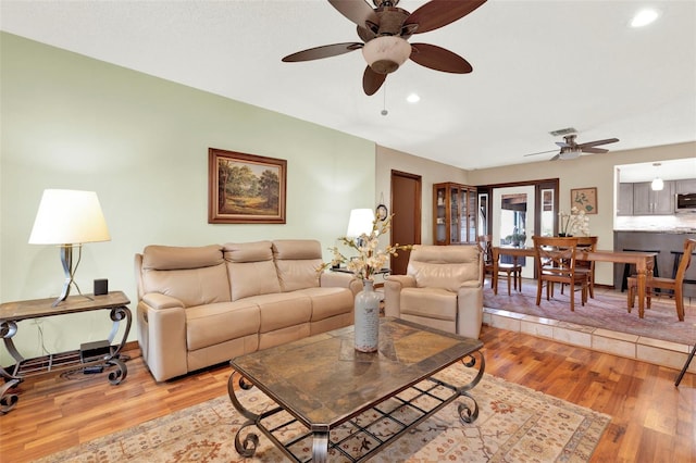 living area featuring light wood-type flooring, a ceiling fan, and recessed lighting