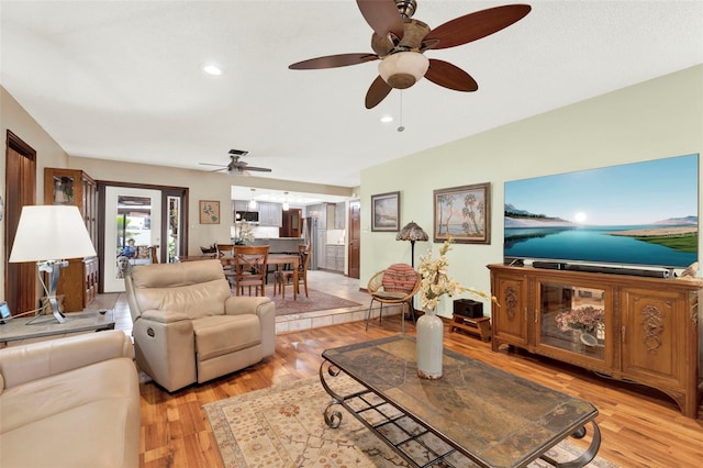 living room featuring recessed lighting, a ceiling fan, and light wood-style floors