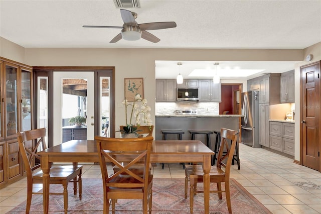 dining space featuring ceiling fan, visible vents, and light tile patterned flooring