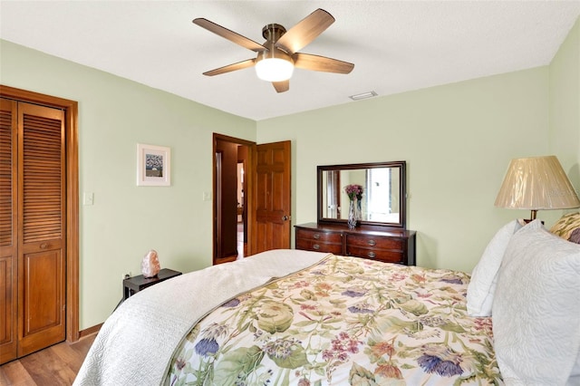 bedroom with ceiling fan, light wood-style flooring, a closet, and visible vents