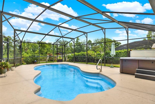 outdoor pool featuring a hot tub, a patio, and glass enclosure