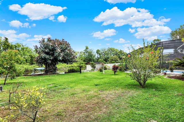view of yard with an outdoor pool and glass enclosure