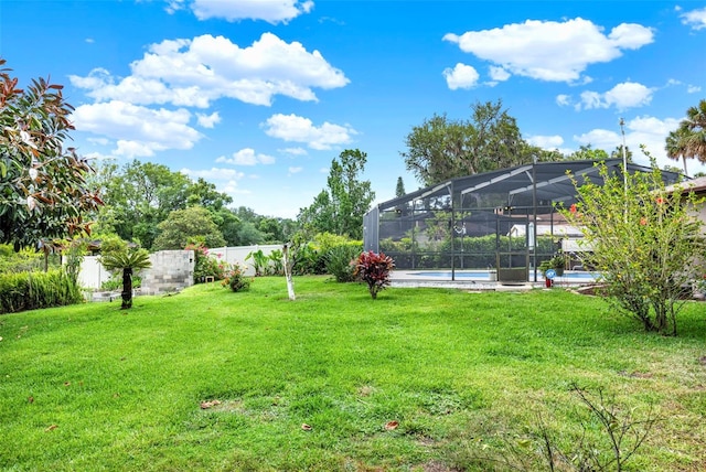 view of yard with fence, a fenced in pool, and a lanai