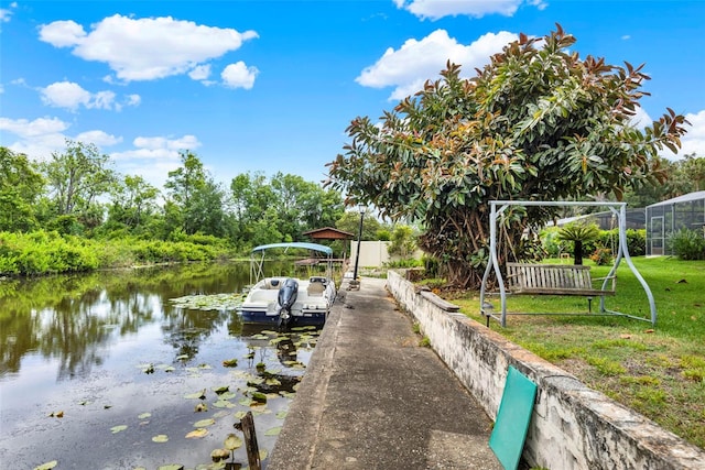 dock area with a water view and a yard