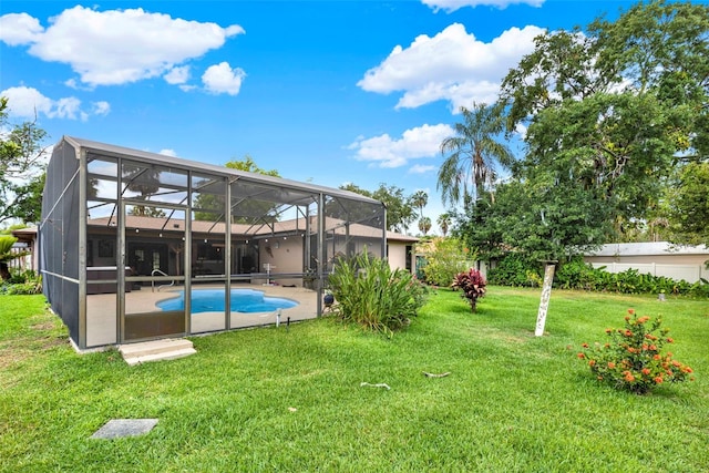 rear view of house with a lawn, a patio, and an outdoor pool