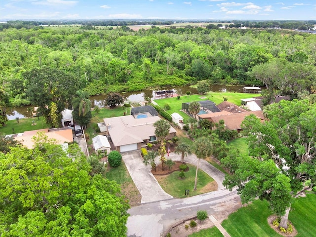 birds eye view of property featuring a water view and a view of trees