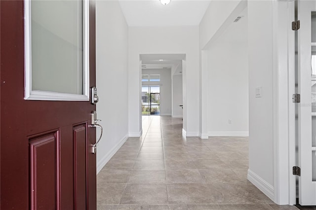 entrance foyer featuring light tile patterned floors, visible vents, and baseboards
