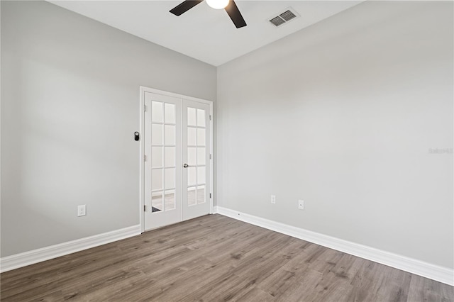 empty room with baseboards, visible vents, wood finished floors, and a ceiling fan