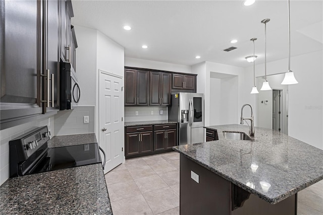 kitchen with a sink, stainless steel appliances, dark brown cabinetry, backsplash, and a large island