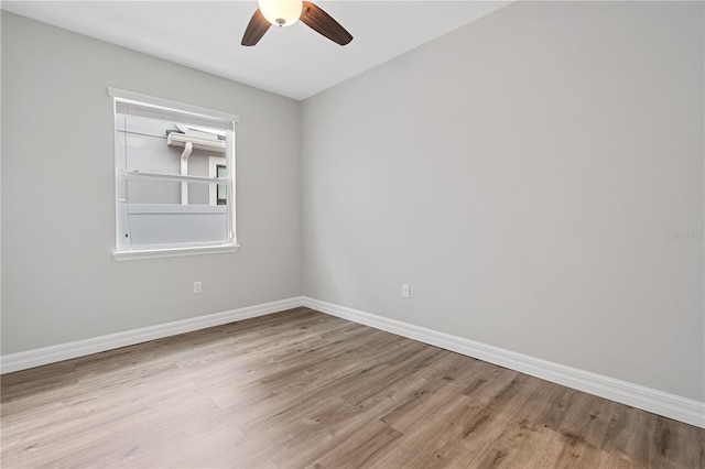 empty room with light wood finished floors, baseboards, and ceiling fan