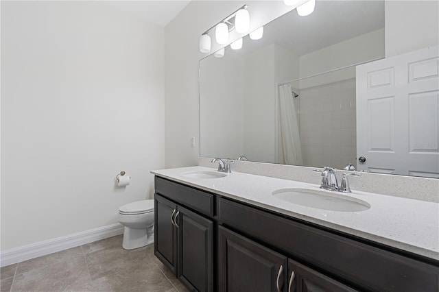 bathroom featuring toilet, baseboards, tile patterned floors, and a sink