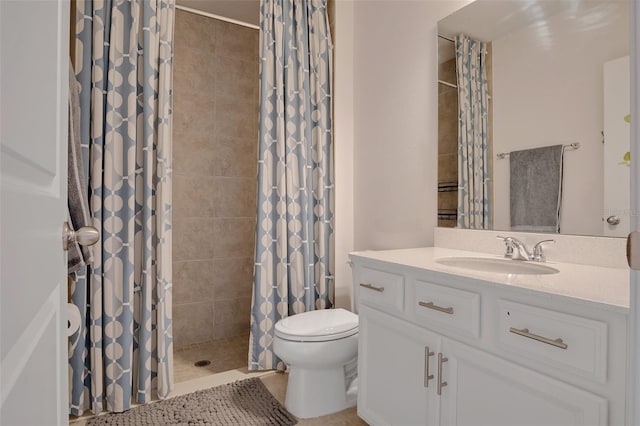 full bath with vanity, a tile shower, and toilet