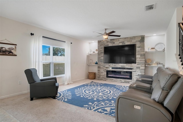 carpeted living room featuring a ceiling fan, baseboards, visible vents, and a large fireplace