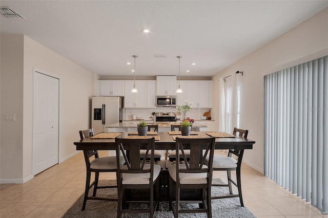 dining area with light tile patterned floors, baseboards, and visible vents