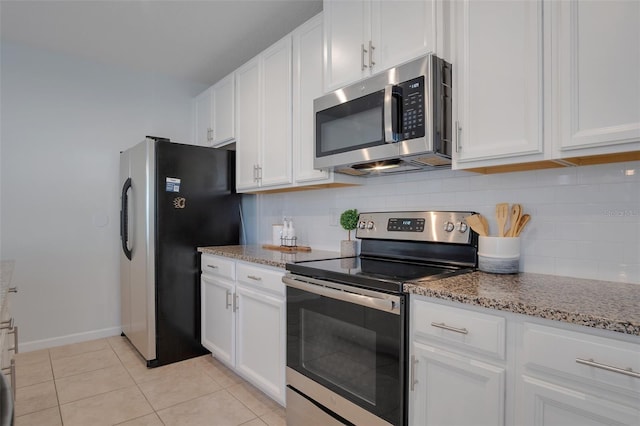 kitchen featuring white cabinets, tasteful backsplash, light stone countertops, and stainless steel appliances