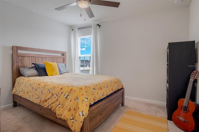 bedroom with light colored carpet, a ceiling fan, and baseboards