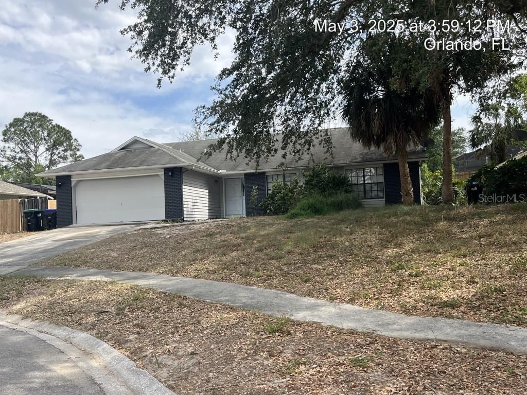 7614 Brisbane Ct, Orlando, FL 32835 - single story home featuring roof with shingles, an attached garage, concrete driveway, and brick siding