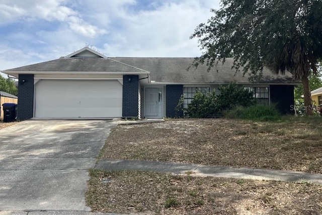 7614 Brisbane Ct, Orlando, FL 32835 - ranch-style house with concrete driveway, brick siding, and a garage