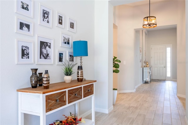 hall featuring baseboards and light wood-type flooring