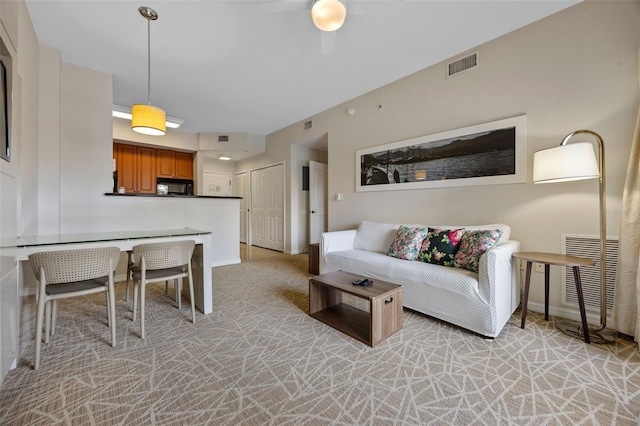7395 Universal Blvd Unit 203, Orlando, FL 32819 - living room featuring light colored carpet, baseboards, ceiling fan, and visible vents