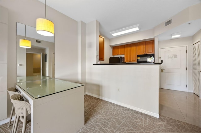 7395 Universal Blvd Unit 203, Orlando, FL 32819 - kitchen featuring a peninsula, black microwave, dark countertops, and visible vents