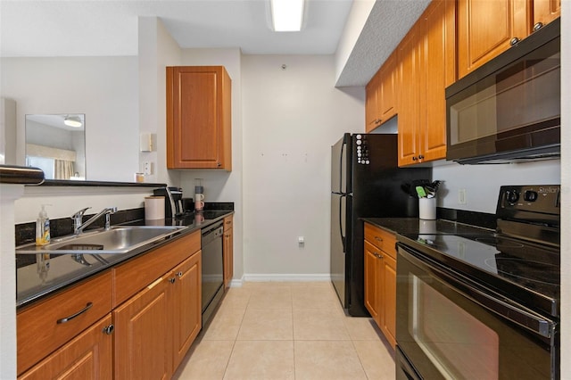 7395 Universal Blvd Unit 203, Orlando, FL 32819 - kitchen featuring light tile patterned floors, a sink, brown cabinets, black appliances, and dark countertops