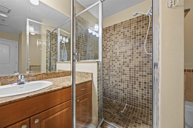 7395 Universal Blvd Unit 203, Orlando, FL 32819 - full bathroom featuring vanity, a textured ceiling, a shower stall, and visible vents
