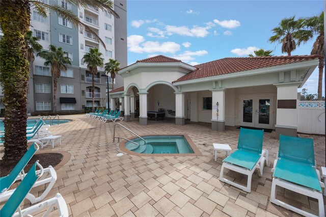 7395 Universal Blvd Unit 203, Orlando, FL 32819 - pool featuring a hot tub, a patio area, and french doors