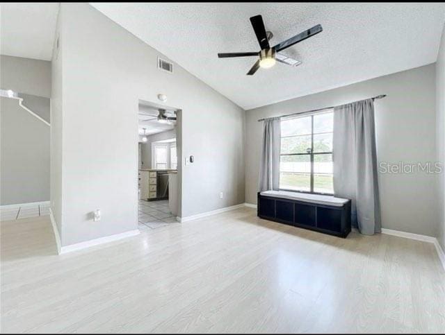 spare room with ceiling fan, visible vents, plenty of natural light, and lofted ceiling