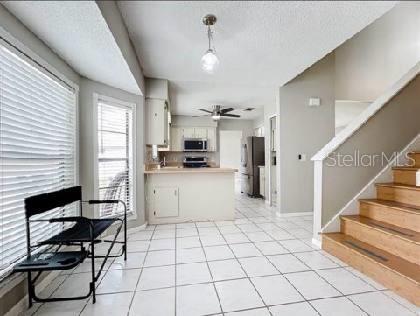 kitchen featuring white cabinets, light countertops, a textured ceiling, stainless steel appliances, and a peninsula