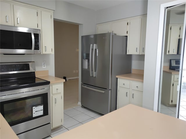 kitchen featuring light countertops, white cabinetry, light tile patterned flooring, and stainless steel appliances