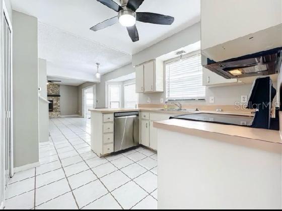 kitchen featuring ceiling fan, dishwasher, light countertops, a peninsula, and white cabinetry