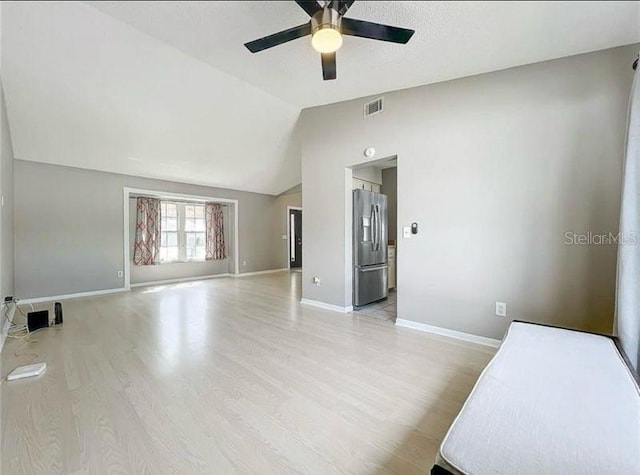 unfurnished room with ceiling fan, light wood-style flooring, baseboards, lofted ceiling, and visible vents