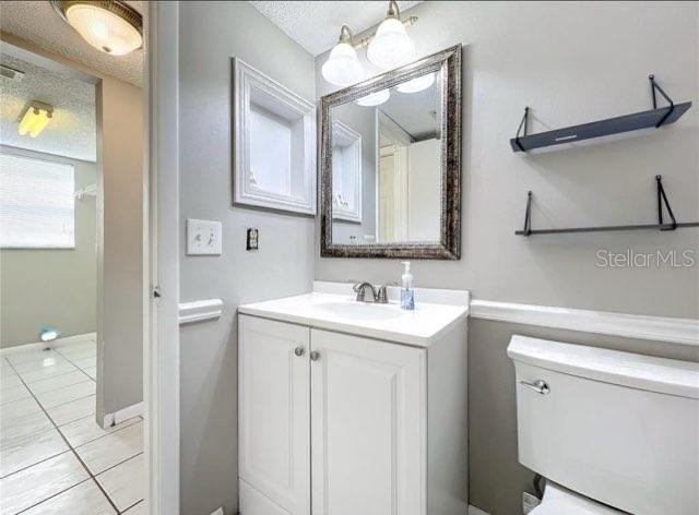 bathroom with tile patterned floors, vanity, and toilet
