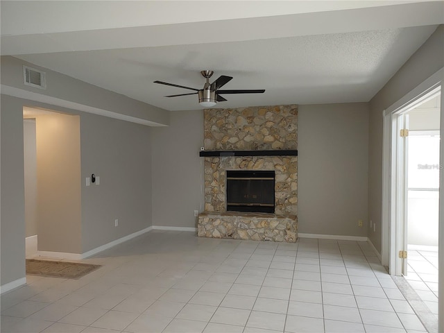 unfurnished living room with ceiling fan, visible vents, a fireplace, baseboards, and light tile patterned flooring