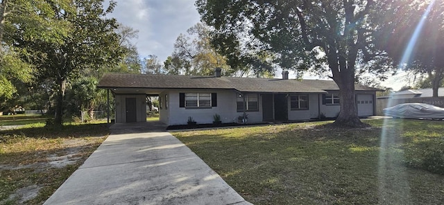 ranch-style house featuring a garage, driveway, a carport, and a front lawn