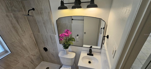 full bathroom with toilet, tile patterned floors, a tile shower, and vanity