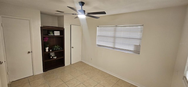unfurnished bedroom with baseboards, a ceiling fan, and light tile patterned flooring