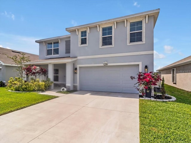 traditional home with concrete driveway, a front yard, stucco siding, and a garage