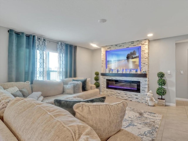 tiled living room with baseboards, a glass covered fireplace, and recessed lighting