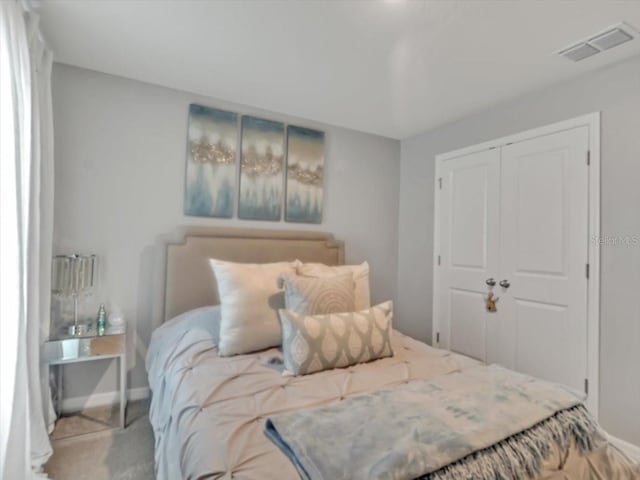 bedroom with baseboards, a closet, visible vents, and carpet floors
