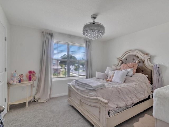 bedroom with an inviting chandelier, light carpet, and baseboards