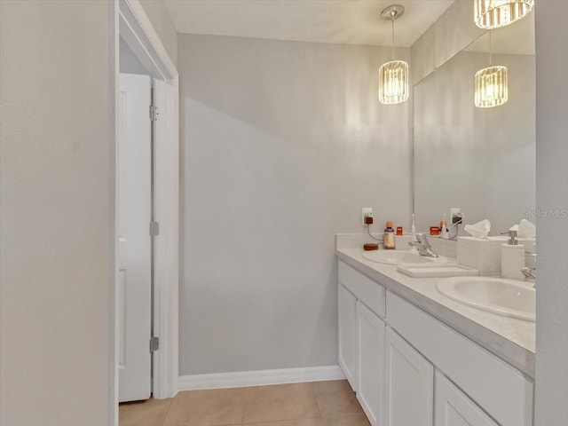 full bath featuring a sink, tile patterned flooring, double vanity, and baseboards
