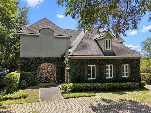 french provincial home featuring stucco siding